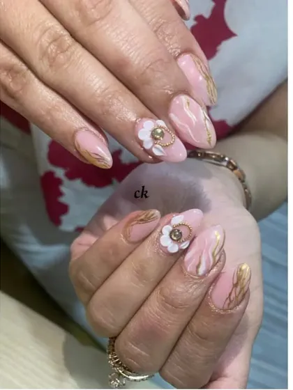 A luxurious design featuring a pink marble base with gold chrome veins and a statement 3D white flower with a gold ring accent.
