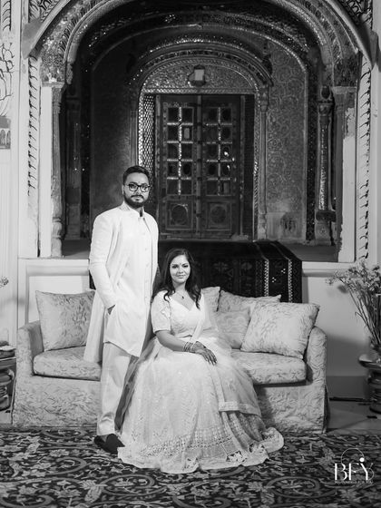 A timeless black and white portrait of a newly engaged couple, posing with regal elegance at a heritage palace in Patiala.