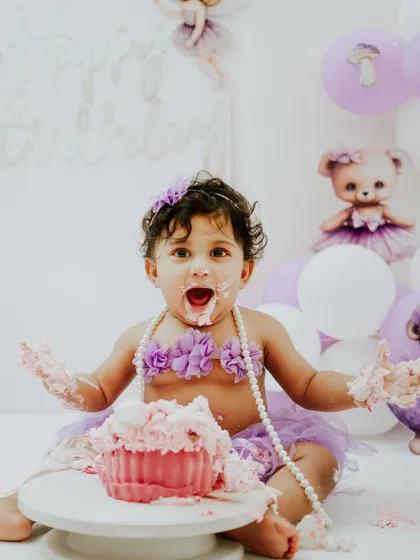 Let's get messy. A cake smash is all about fun, and this little one is having the time of her life during her purple teddy bear themed session. I handle the setup and the cake, you just bring the baby.