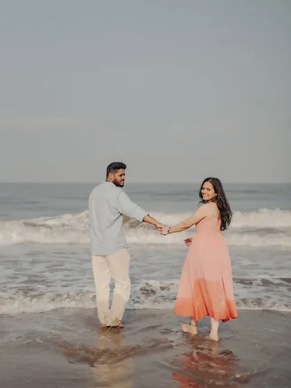 A candid moment from Anushka and Manu's beach pre-wedding session. This relaxed, "follow me" style captures the joy and movement of their connection against the ocean waves.