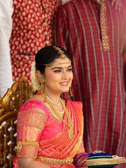 The bride seated on the ceremonial chair, looking regal and serene. The makeup is designed to give her a polished and graceful appearance throughout the long rituals.