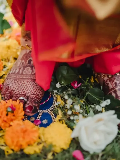 Another view of the bride's feet amidst flowers, the dark henna stain adding to the beauty of the ritual.