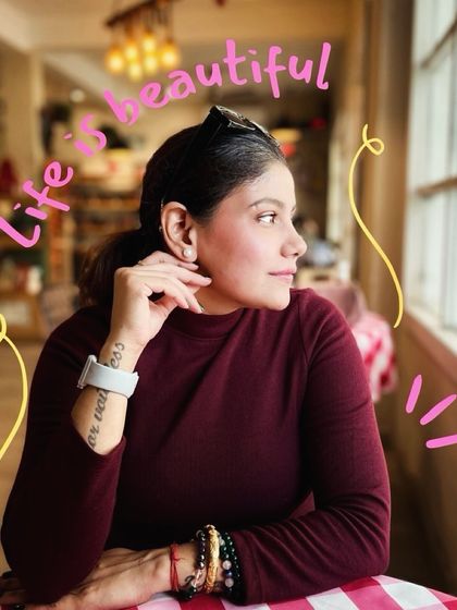 A candid shot of me looking out a cafe window, capturing a moment of quiet reflection. The doodle 'Life is beautiful' adds a touch of my personal, dreamy aesthetic.