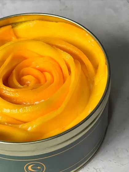 A close-up of the fresh, juicy mango that crowns our seasonal Tres Leches cake. We believe in using only the best ingredients.