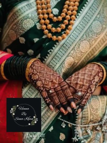 A beautiful shot of a bride's hands, showcasing a traditional check and floral design that perfectly complements her sari and jewelry.