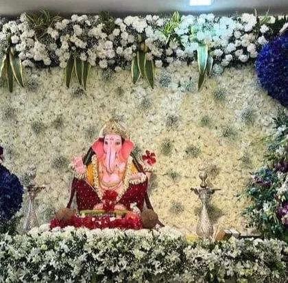 An extravagant and artistic Ganpati mandap featuring two majestic peacocks made entirely of fresh flowers. This design is a testament to my team's skill in creating bespoke floral sculptures for a truly grand celebration.