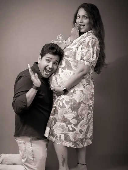 A fun and expressive black and white photo. The dad-to-be's excited expression as he listens to the baby bump brings a sense of joy and playfulness to this family maternity session.