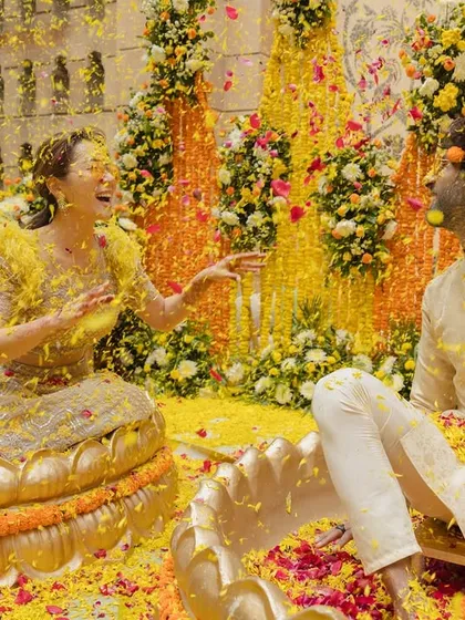 The Haldi ceremony should be filled with joy and laughter. I create vibrant, playful settings where couples can relax and share candid moments, like this one amidst a shower of colorful flower petals.