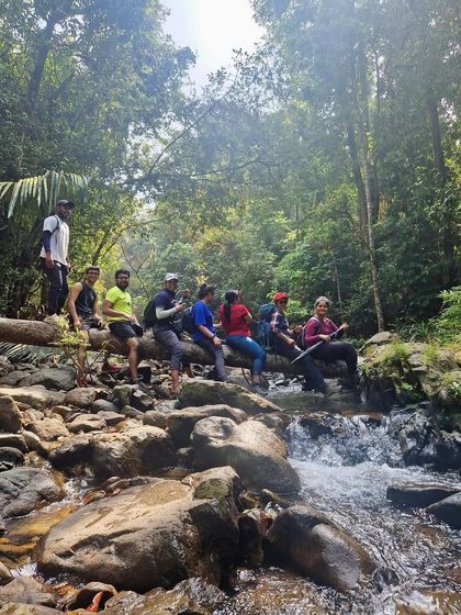 Taking a break in a stream during a forest trek in Karnataka. These small moments of rest and connection with nature are what make our trips special.