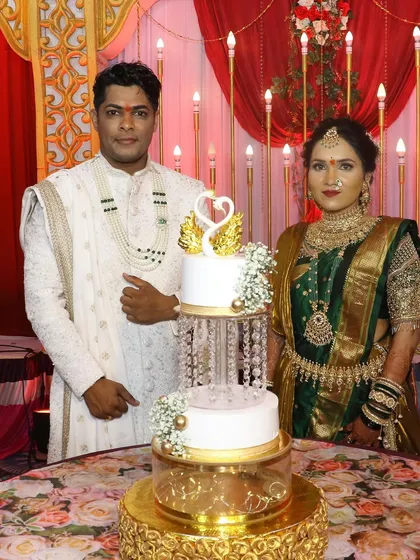 A proud moment for the couple as they stand with their grand engagement cake. The swan topper and crystal details make it a truly special centerpiece.