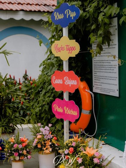 Fun and quirky signage is a must. This "Khao Piyo, Nacho Tappo" sign perfectly captures the celebratory mood of a Mehendi or Haldi event.