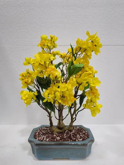 A beautiful flowering artificial bonsai with bright yellow blossoms, bringing a cheerful and spring-like feel to any room.