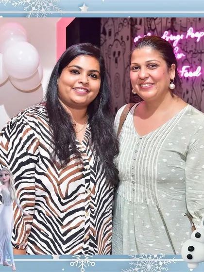 Two moms posing for a photo during a Frozen-themed party. We love seeing parents relax and create their own happy memories at our events.