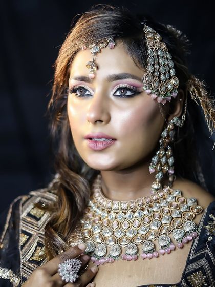 A close-up portrait highlighting the pastel-toned jewelry and the soft, glowing makeup.