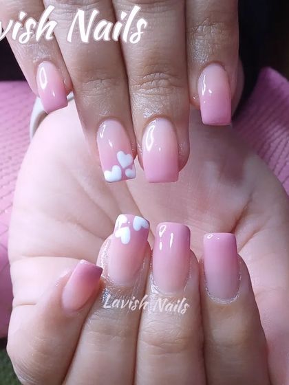 A soft pink ombre set on shorter square nails with a cute, tiny white heart accent.