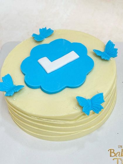 A closer look at the "verified" checkmark cake, complete with blue butterflies.