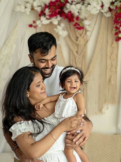 A family of three, sharing a happy moment in our bright, boho studio. The smiles say it all.