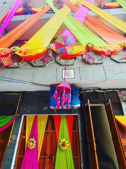 A home decorated with colourful drapes and traditional hangings, creating a classic 'shaadi wala ghar' look.