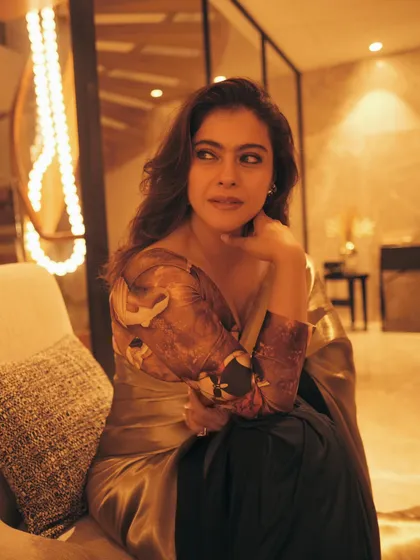 The warm, golden lighting of the room perfectly matches the tone of this stunning bronze saree.