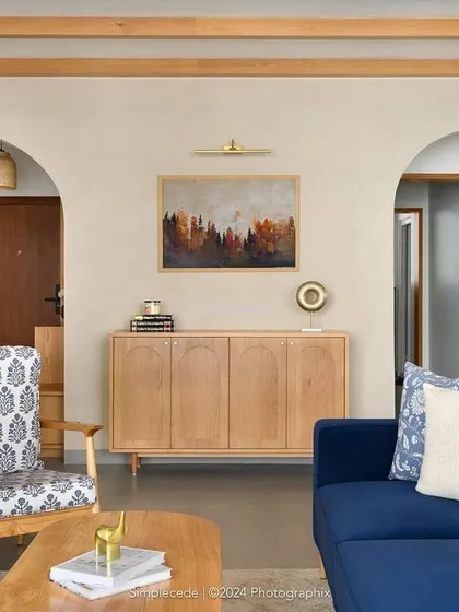 The second wall of the 'Cover me in Sunshine' living area, featuring two elegant arched entries, a custom sideboard, and a bar unit, all unified by overhead rafters.