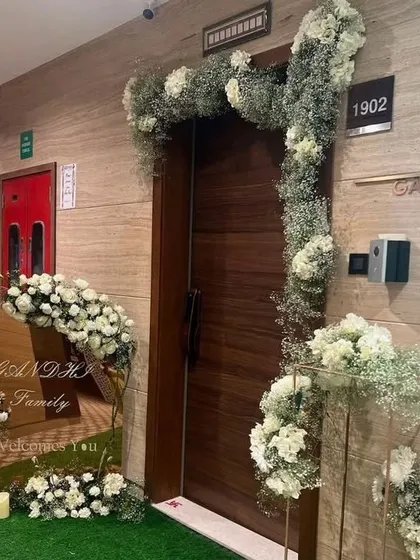 Your welcome starts at the door. We designed this chic and rustic entrance using white roses, baby's breath, and natural wood elements to create a warm and inviting welcome for the Gandhi family's guests.