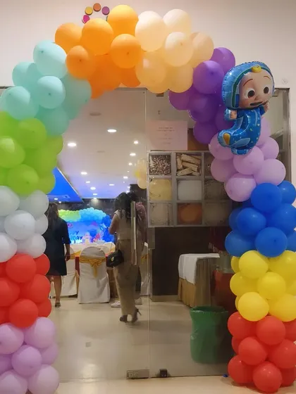 A colorful Cocomelon-themed entrance arch welcoming guests to Punyakshi's first birthday party.