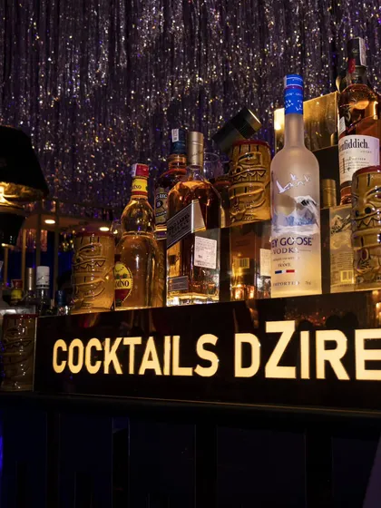 A close up of our branded bar shelf. The illuminated "Cocktails Dzire" logo and premium liquor display add a professional and high end touch to any event setup.
