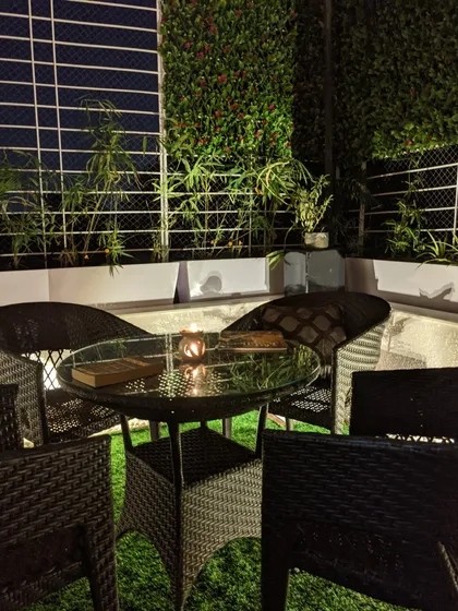 This is the feeling I aim to create: a quiet moment of peace after a long day. The warm glow from the candle on the wicker table, surrounded by the soft textures of the vertical garden and turf, makes this balcony a perfect nighttime oasis.