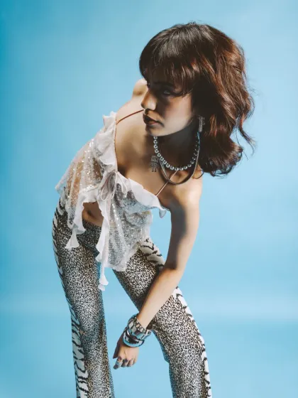 "Wild Glamour" was the theme. The bright blue background makes the sequined top and animal-print pants pop, creating a vibrant, high-energy fashion shot.