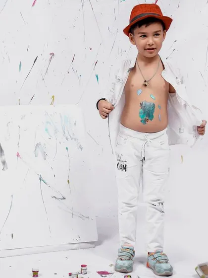 A fun, candid moment from the painter theme, with the little boy showing off his paint-splattered tummy with a big smile.