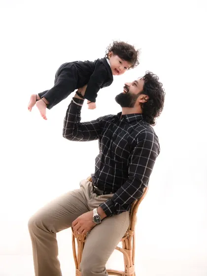 Flying high. This joyful shot of a father lifting his son into the air captures a moment of pure, exhilarating fun during a classic family session.