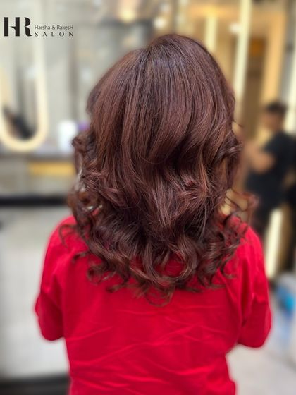 A beautiful auburn global color styled with soft curls, showing the richness of the shade.