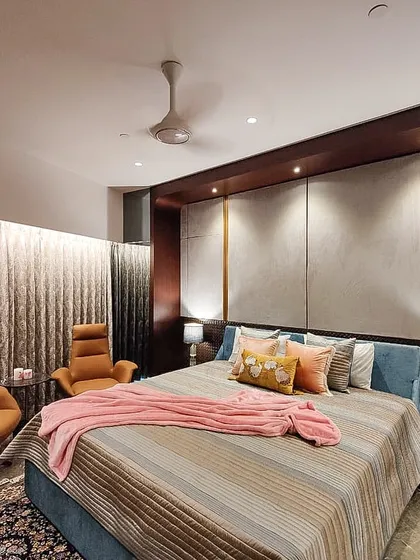 The master bedroom in the Jesrani Residence, designed as a serene retreat. We used a soft, upholstered headboard, warm accent lighting, and rich textiles to create a comfortable and sophisticated space for rest and relaxation.