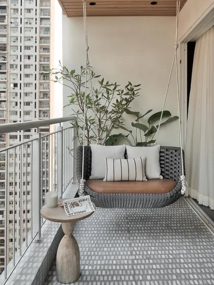 This serene balcony is a personal oasis amidst the vibrant Mumbai cityscape. The elegant cement-finish floor, with its calming shades of grey and white, sets the stage for a tranquil retreat.