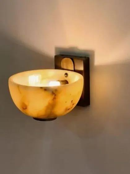 A close-up of the alabaster wall sconce, highlighting the beautiful translucency and natural patterns of the stone.