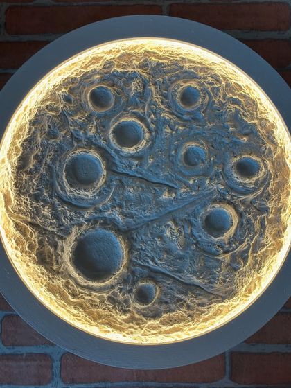 My 18-inch Moon Lamp with the LED light on. The light emanates from behind the textured surface, highlighting the craters and creating a beautiful, ethereal glow perfect for any space.