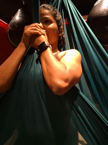 A close-up showing the arm and shoulder engagement required in aerial yoga. It's a discipline that builds lean, functional muscle in a way that is very different from traditional weightlifting.
