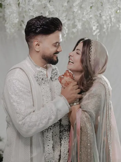 A joyful, candid moment from the celebrity wedding. The all-white decor, with its layers of flowers and fabric, provides a perfect, unobtrusive canvas for capturing genuine emotion.