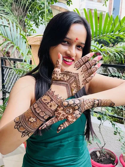 A happy client is the best reward for my work. Here she is, glowing with joy and showing off her intricate engagement mehndi, filled with traditional motifs and personalized details.