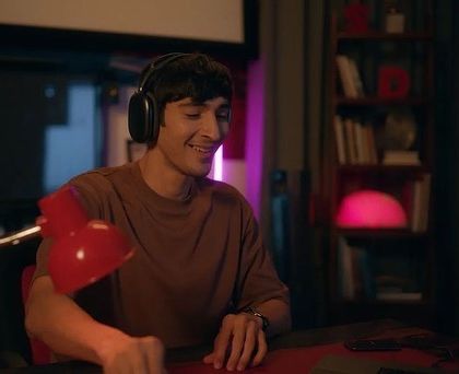 This shot shows a character in a creative, personal space. The comfortable brown t-shirt and headphones create a look that is casual, modern, and focused.