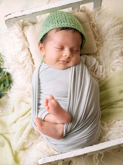 A simple, clean wrap in a neutral color allows the baby's peaceful expression to be the star. The little feet peeking out at the bottom is one of those details you'll want to remember.