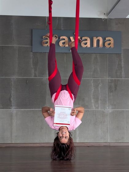 The pure joy of accomplishment. One of our students hangs upside down, certificate in hand, after completing her aerial teacher training. This is a moment of pure pride and a new perspective.