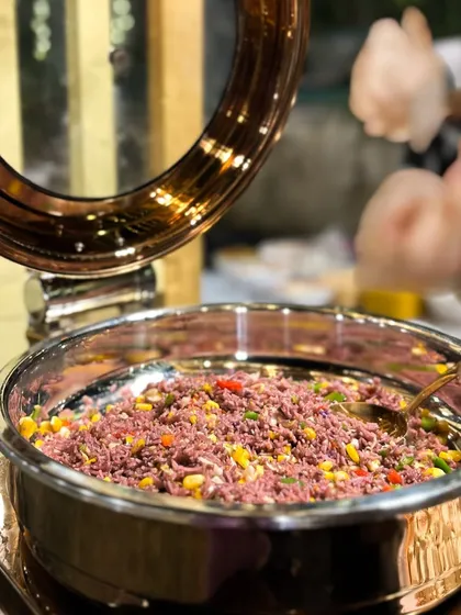 A buffet view of the Purple Rice, mixed with colourful corn and peppers. This dish adds a vibrant splash of colour to any buffet line and offers a unique, flavourful rice option for guests.