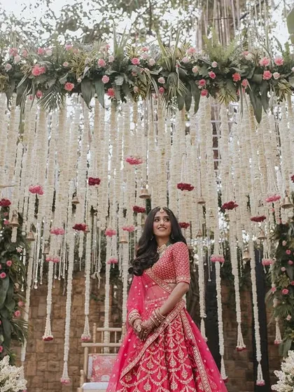 A beautiful bride framed by our traditional floral mandap. We used strings of rajnigandha and pops of pink to create a classic, elegant backdrop that honors timeless traditions.