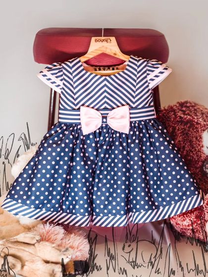 A playful mix of patterns in this navy and pink dress, combining chevron stripes on the top with polka dots on the skirt.