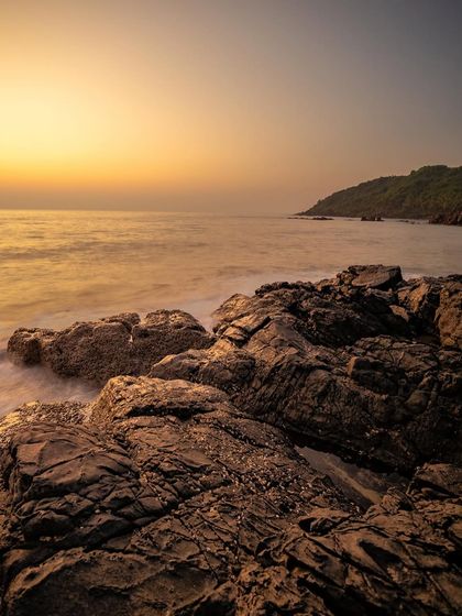 A vertical composition of a rocky sunset, where the warm light on the horizon contrasts with the cool tones of the sky.
