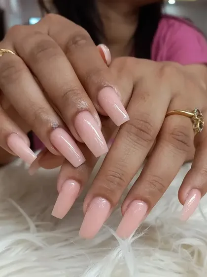 This showcases the beauty of a simple, elegant manicure. We used a soft, natural pink shade on long, coffin-shaped nails to create a polished and sophisticated look suitable for any occasion.