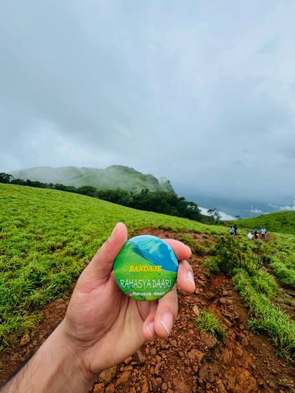 The Bandaje trek badge against the rolling green hills of the trail. A perfect memory of the journey.