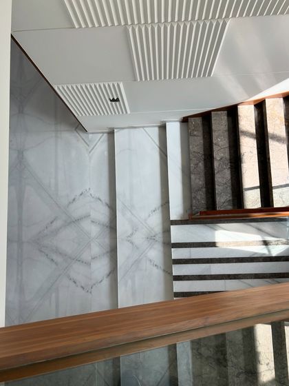 A top-down view showing the geometric patterns of the marble flooring at Gulmohar Farmhouse, demonstrating a meticulous attention to detail in even the transitional spaces.