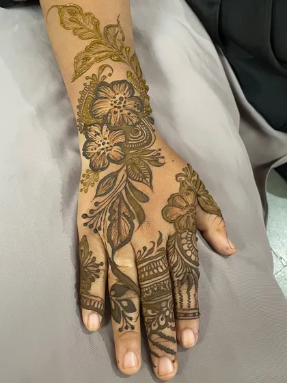 A delicate floral design on the back of the hand, perfect for a party or special occasion.